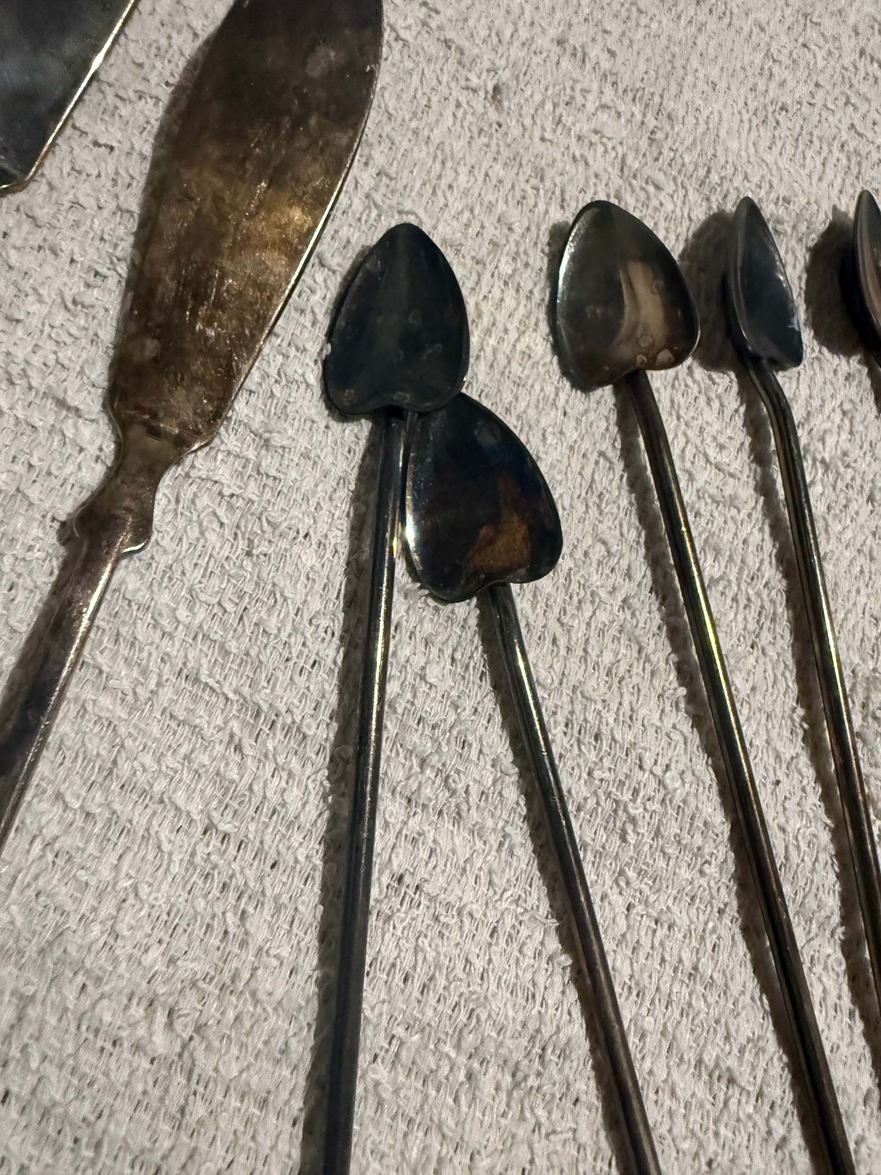 Close-up of tarnished silver spoons and utensils before polishing